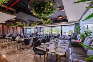 a dining room with tables and chairs and large windows at فندق كورنيت النورس - جدة in Jeddah