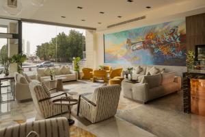 a living room with a large painting on the wall at فندق كورنيت النورس - جدة in Jeddah