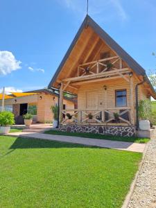 a house with a wooden roof with a porch at Koliba La Perla in Banja Luka