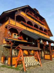 a building with a balcony and a bench in front of it at Pensiunea Codrea - Wagner in Lazu Baciului