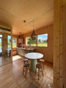a kitchen and dining room with a table and chairs at Pagalėlių namai in Voveriai