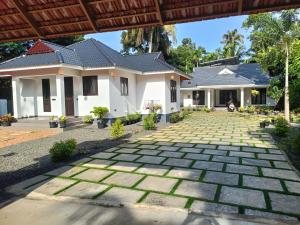 a house with a stone pathway in front of it at Casa Luminaria in Alleppey
