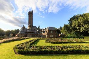 an estate with a clock tower in the middle of a garden at 't Achterhuis (8 persons) in Otterlo