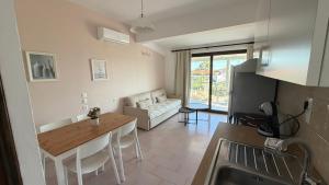 a kitchen and living room with a table and a couch at Golden Evelyn in Agia Paraskevi
