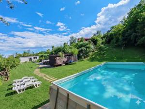 a backyard with a swimming pool and lawn with white chairs at Epic Glamping in Călimăneşti