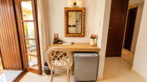 a bathroom with a vanity with a mirror and a chair at Enetiko Rooms in Chania +91 photos