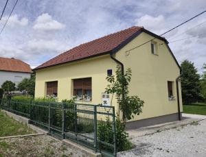 a yellow house with a fence in front of it at Kuća za odmor Dankica in Veliko Trgovišće