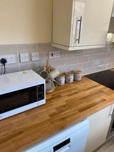 a kitchen with a white microwave on a wooden counter at Bide a Sea in Gorleston-on-Sea +47 photos