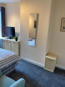 a bedroom with a bed and a mirror at Bide a Sea in Gorleston-on-Sea