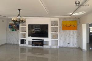 a living room with a flat screen tv on a wall at Holiday Villa Marondera in Marondera