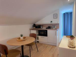 a kitchen and dining room with a table and chairs at Appartement Cosy avec parking à proximité de la Gare et de toutes les commodités in Orléans +19 photos