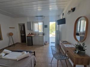 a room with a bed and a table and a kitchen at Sea view Lefkes in Kithnos +34 photos