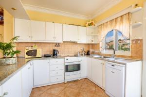 a kitchen with white cabinets and a window at Spacious 2BR Apartment with Balconies in Karpathos +14 photos