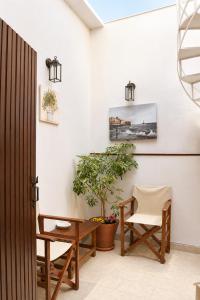 a room with a table and a chair and a plant at Enetiko Rooms in Chania