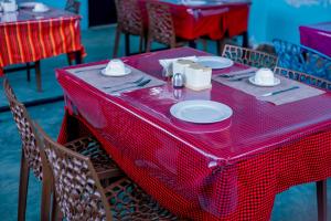 a red table with plates and napkins on it at Olivia Green Lodge in Arusha