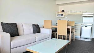 a living room with a couch and a kitchen at Darwin Harbour Sunset Views in Darwin