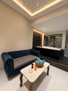 a living room with a blue couch and a table at Hotel Nova Bloom in Ahmedabad +111 photos