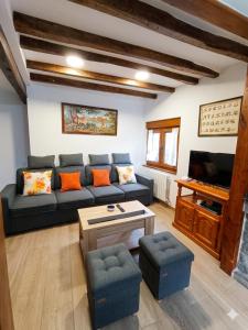 a living room with a couch and a tv at Casa Vacacional Villa Martina in Valmeo