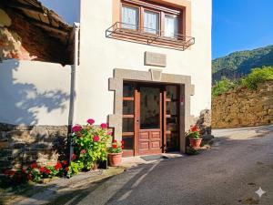 a building with a door and flowers in front of it at Casa Vacacional Villa Martina in Valmeo