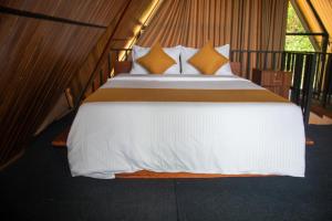 a bedroom with a bed with white sheets and yellow pillows at Nine Mist Heaven in Ella