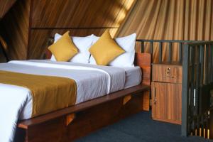 a bedroom with a bed with yellow and white pillows at Nine Mist Heaven in Ella +5 photos