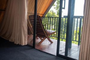 a wooden rocking chair on a porch with a window at Nine Mist Heaven in Ella