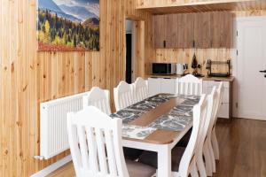 a dining room with a table and white chairs at Melody Hotel in Bukovel