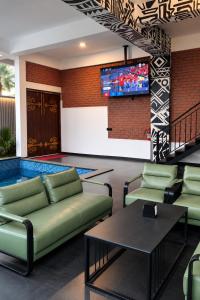 a living room with couches and a tv on a wall at Atmosfera Bengaluru, India in Bangalore