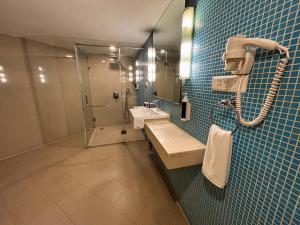 a bathroom with a sink and a shower at Peerless Hotel Hyderabad in Hyderabad +40 photos