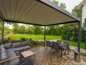 a patio with a couch and a table and chairs at Forest House Premium Breaza in Breaza de Sus