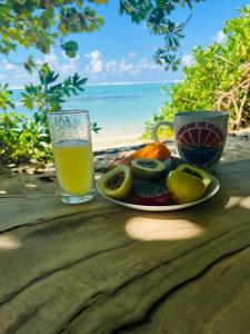 a plate of fruit and a cup of orange juice at Parea Lodge Huahine BUNGALOW F2 #Miti in Parea