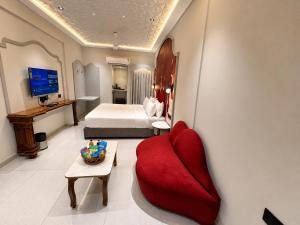 a hotel room with a red couch and a bed at Hotel Nova Bloom in Ahmedabad