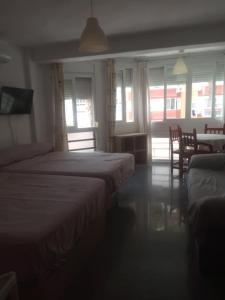 a bedroom with two beds and a table and chairs at Estudio Plazamar in Torre del Mar +14 photos