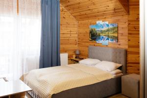 a bedroom with a bed in a wooden wall at Melody Hotel in Bukovel