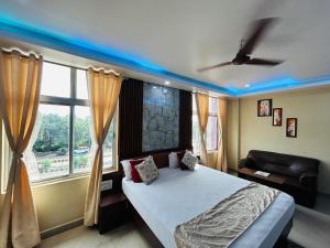 a bedroom with a bed and a couch and windows at Hotel Sky View in Aurangābād +16 photos