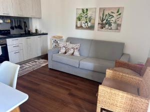 a living room with a couch and a kitchen at home SIKAN casa al mare Licata in Butera