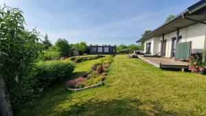 a yard with a building and a garden with flowers at Villa Las Palmas in Strzeszów