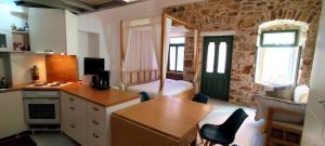 a kitchen with a table and a room with a bedroom at Loft House Syros in Ermoupoli