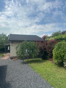 a house with a tree in front of it at Gréta Apartman in Ábrahámhegy