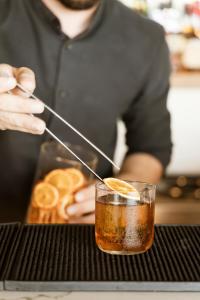 a person is stirring a drink with a spoon at NĒRO Boutique Hotel in Imerovigli +32 photos