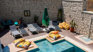 an overhead view of a pool with chairs and umbrellas at Kiva Alaçatı Hotel By Amarillo in Çeşme