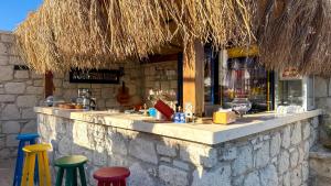 a bar with colorful stools in front of a building at Kiva Alaçatı Hotel By Amarillo in Çeşme