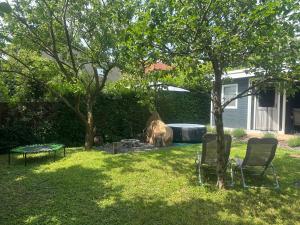 a backyard with two chairs and a dog in the yard at Gréta Apartman in Ábrahámhegy +2 photos