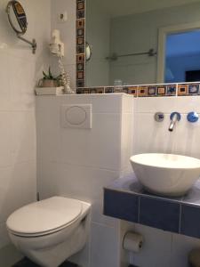 ein Badezimmer mit einem weißen WC und einem Waschbecken in der Unterkunft Pension Glücklich in Horgenzell