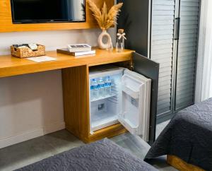 a small refrigerator with its door open under a desk at Kiva Alaçatı Hotel By Amarillo in Çeşme