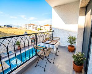 a balcony with a table and chairs and a swimming pool at Kiva Alaçatı Hotel By Amarillo in Çeşme