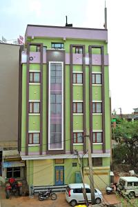 a green building with cars parked in front of it at Gehlot Paradise Hotel in Nāgaur