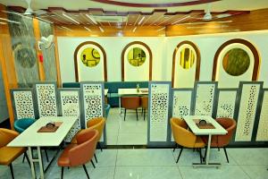 a dining room with tables and chairs and windows at Gehlot Paradise Hotel in Nāgaur