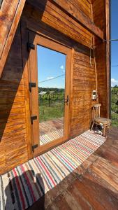 an open door of a wooden cabin with a window at Căsuța Casper in Tudora