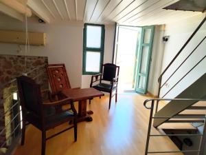 a room with two chairs and a table and a staircase at Loft House Syros in Ermoupoli